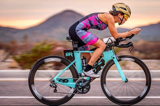 Athlete Christine Warren sitting in a chair with a bike to her side